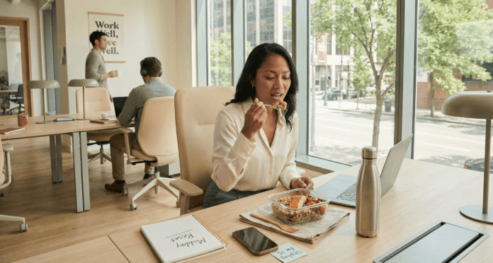 A professional woman enjoys a balanced homemade lunch at her sun‑lit desk, illustrating smart nutrition for working women through mindful eating, calm focus, and sustainable everyday wellness at work.