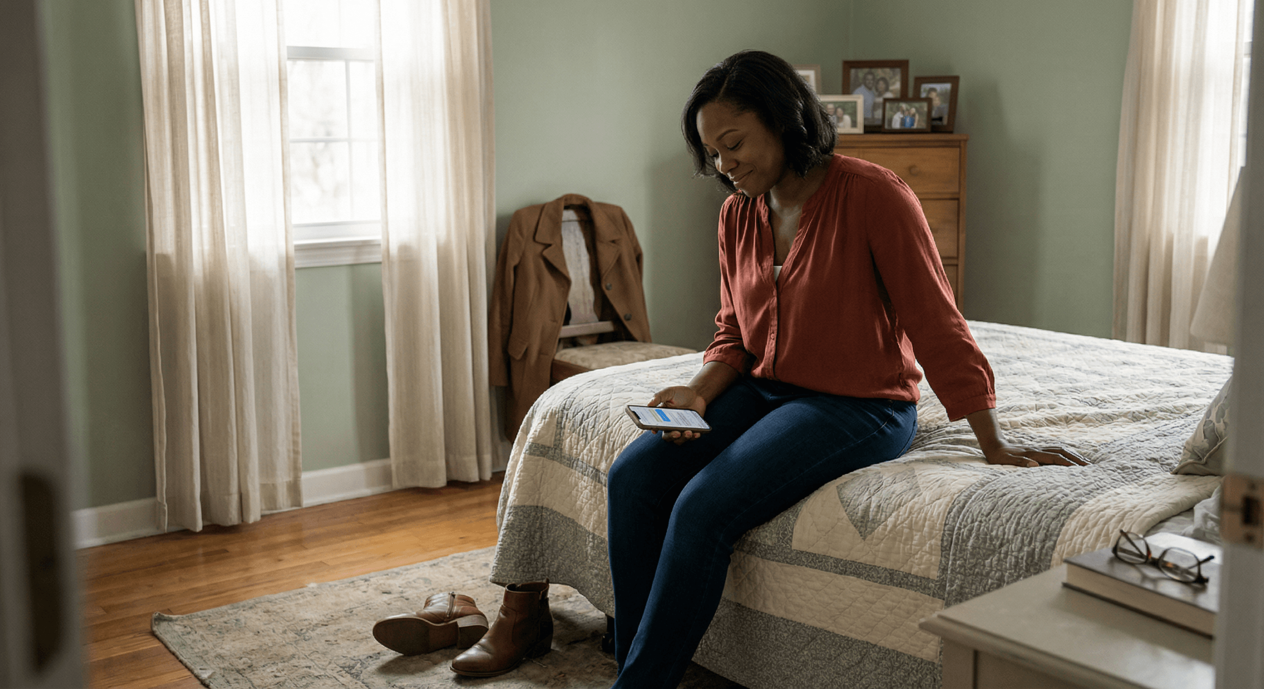 Black woman sitting on bed looking at text messages from children while navigating intentional dating after divorce and parenting responsibilities