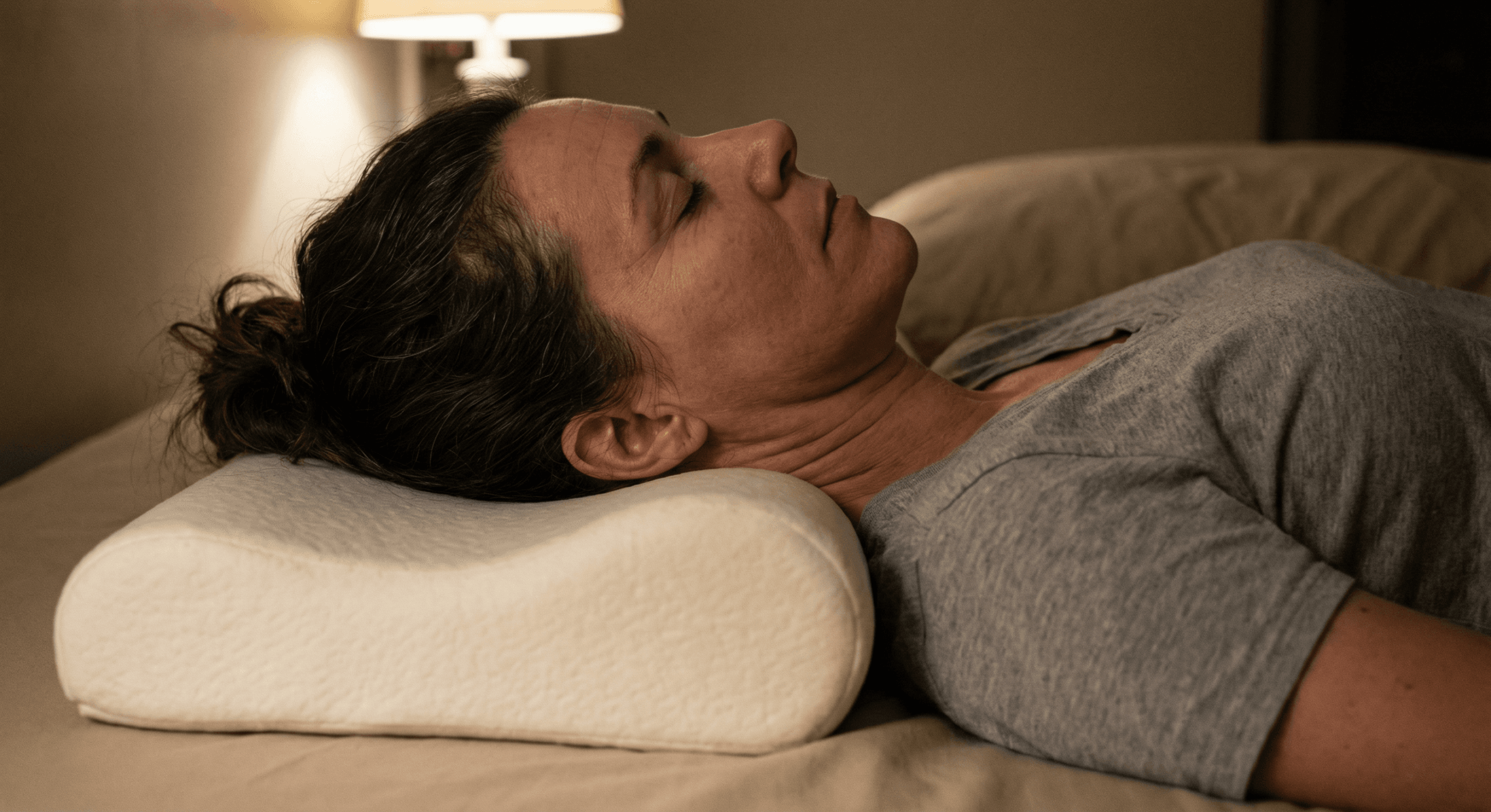 Woman lying on side with head resting on contoured memory foam pillow supporting neck alignment
