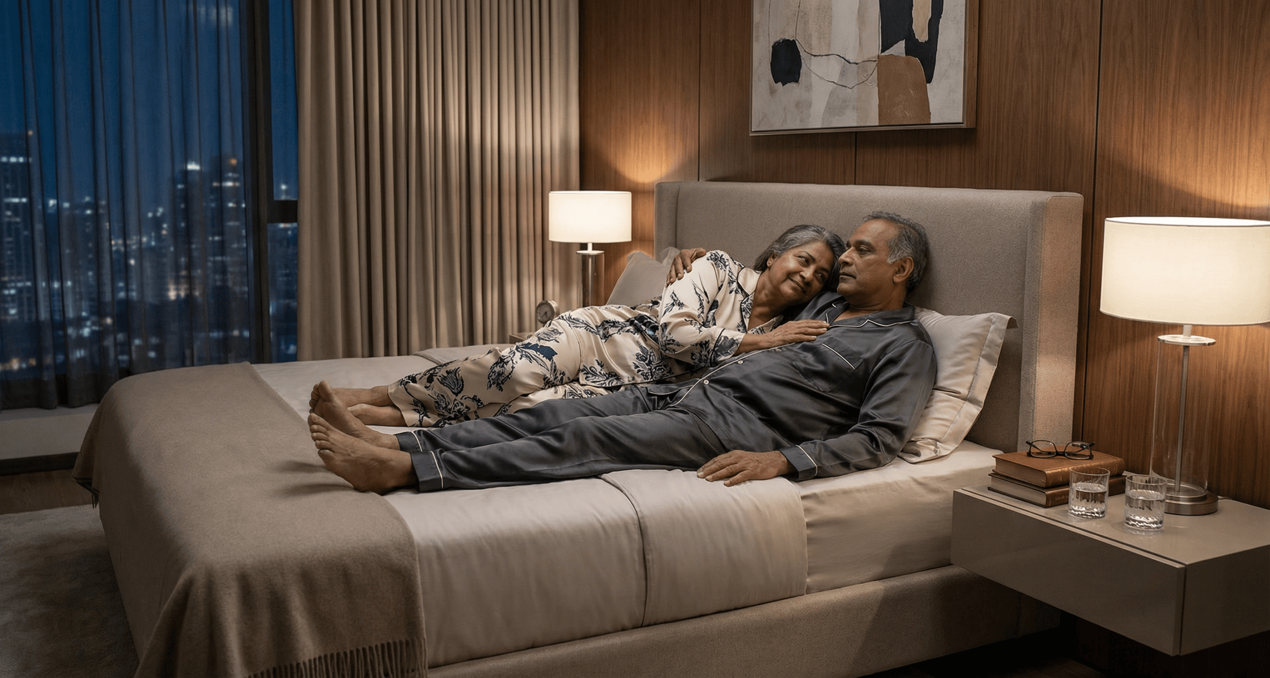 South Asian couple lying close in bed during pre-dawn with hand on chest showing evolved physical intimacy of aging as a couple